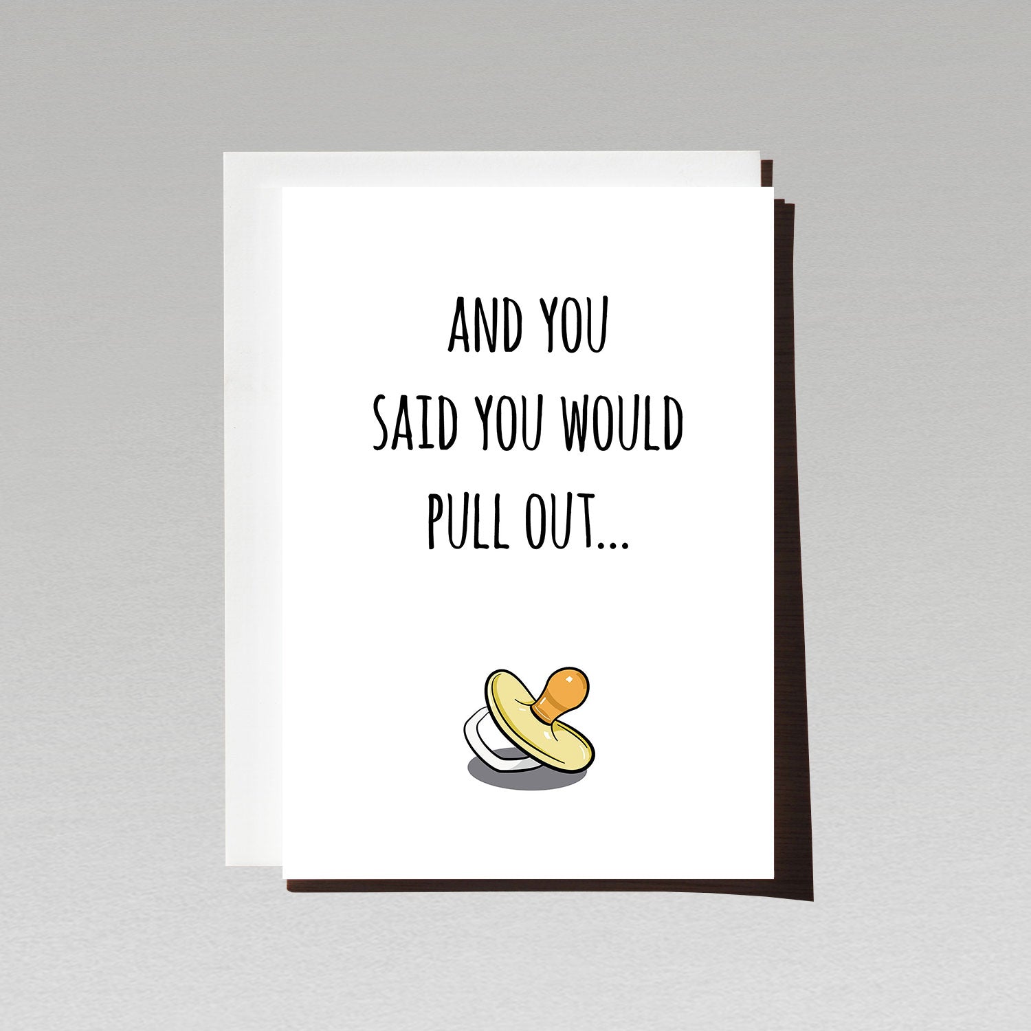 pregnancy reveal greeting card with yellow pacifier on white background with text and you said you would pull out